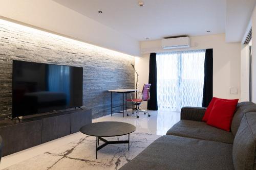 a living room with a couch and a flat screen tv at CREAL premier Akasaka in Tokyo
