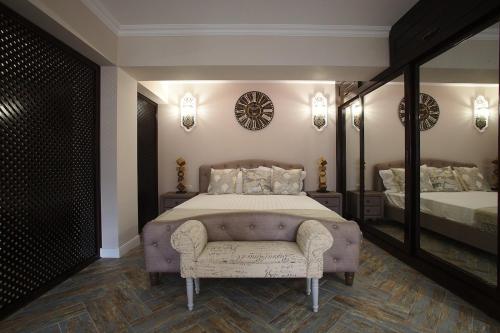 a bedroom with a bed and a chair and a mirror at Apartament AMBER CHRISTMAS MARKET in Brăila