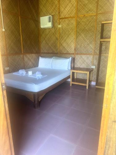 a room with a bed and a table in a room at Diamond De Siquijor Beach House in Siquijor