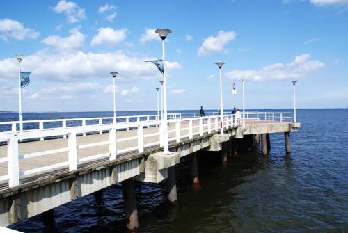 a white pier with flags on it in the water at Kawalerka Nad Morzem in Gdańsk