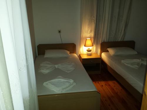 two beds in a bedroom with a lamp on a table at Villa Niki in Loutro