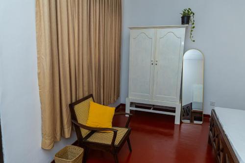 a room with a yellow chair and a cabinet at The Hide in Sri Jayewardenepura Kotte