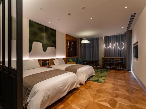 a hotel room with two beds and a table at GREENITY IWATA in Iwata