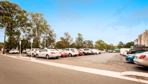 a row of cars parked in a parking lot at Greenacre Hotel in Sydney