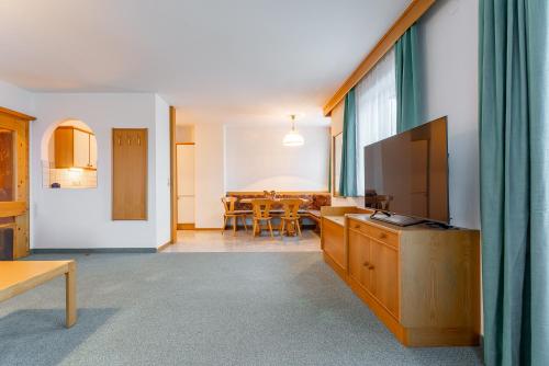 a living room with a television and a dining room at Apartment Sonnberg in Mittersill