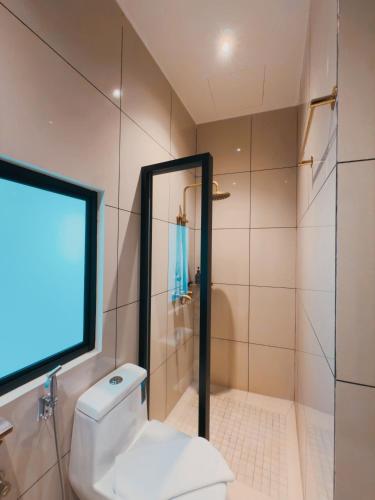 a bathroom with a shower and a toilet and a tv at Hotel Penaga in George Town