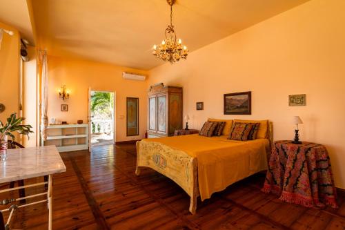 a bedroom with a bed and a table and a chandelier at Blue Rhapsody Villa in Glacis