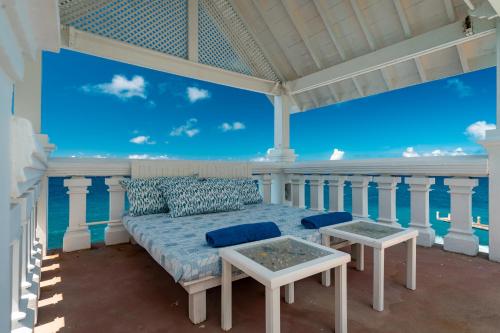 a bed on a porch with a view of the ocean at Blue Rhapsody Villa in Glacis