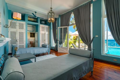 a living room with two beds and a view of the ocean at Blue Rhapsody Villa in Glacis