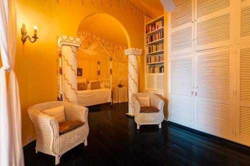a room with a bed and two chairs and a mirror at Blue Rhapsody Villa in Glacis