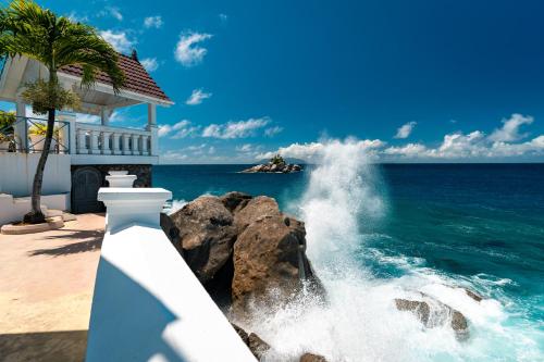 a wave crashing against a building near the ocean at Blue Rhapsody Villa in Glacis