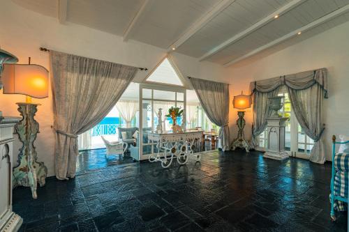 a large living room with a table and windows at Blue Rhapsody Villa in Glacis
