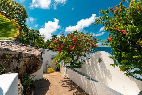 a white fence with flowers on the side at Blue Rhapsody Villa in Glacis
