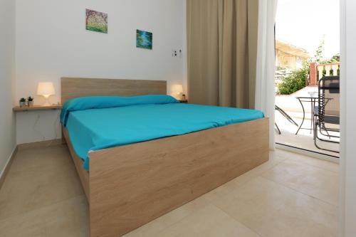 a bedroom with a bed and a balcony at Astro apartments with direct access on the sea of Noto heritage of Unesco in Noto