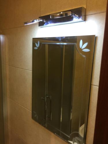 a mirror in a bathroom with a light above it at Alraha village-aqaba قرية الراحة- مرسى زايد -العقبة in Aqaba