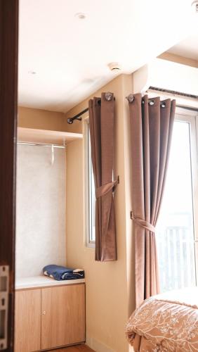 a bedroom with a bed and a window with curtains at 3BR Apartemen Sudirman Bandung in Bandung