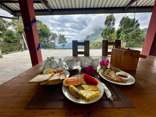 a wooden table with plates of food on it at Beyond Nomad Luxury Hostel in Ella