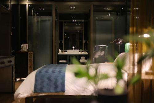 a bedroom with a bed with a blue and white blanket at Sanya Yalong Bay Danqiu Castle Manor Hotel in Sanya