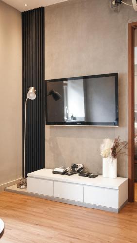 a white table in a room with a tv on the wall at 2BR Apartement Sudirman Bandung in Bandung
