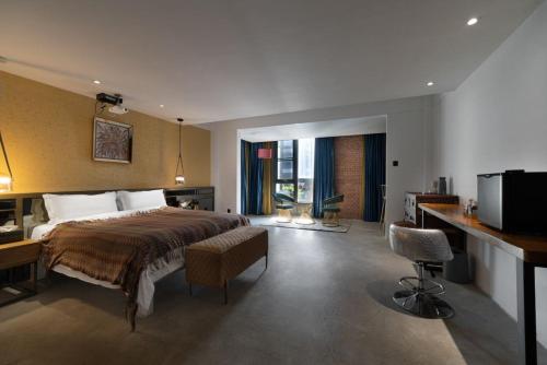 a bedroom with a bed and a desk and a television at Sanya Yalong Bay Danqiu Castle Manor Hotel in Sanya