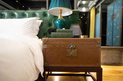 a bedroom with a bed with a suitcase next to a lamp at Sanya Yalong Bay Danqiu Castle Manor Hotel in Sanya