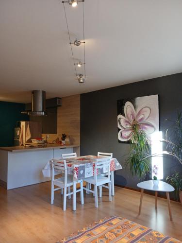 une cuisine et une salle à manger avec une table et des chaises dans l'établissement Petit studio tout confort, à Métabief