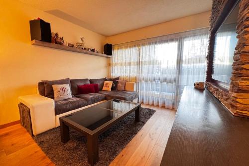 un salon avec un canapé et une table basse dans l'établissement Apartment with balconies on the snow front, à Megève
