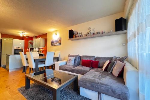 un salon avec un canapé et une table dans l'établissement Apartment with balconies on the snow front, à Megève