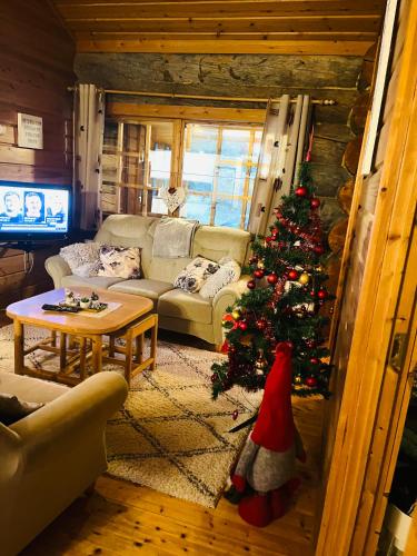 a living room with a christmas tree in a room at Villa Karhuntähti in Luosto