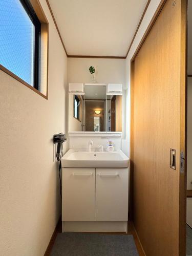 a bathroom with a white sink and a mirror at sun inn in Tokyo