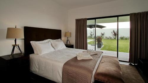 een slaapkamer met een groot bed en een groot raam bij Vila D`Obidos in Casal da Lagoa Seca