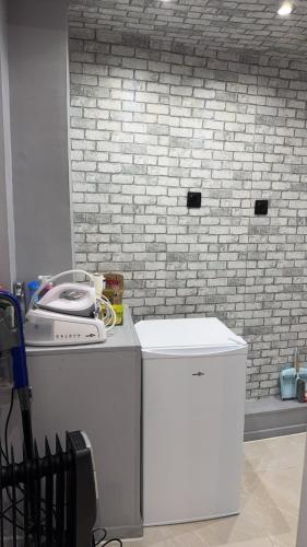 - un lave-linge et un sèche-linge dans une pièce dotée d'un mur en briques dans l'établissement Hébergement jacuzzi très silencieux, à Deuil-la-Barre