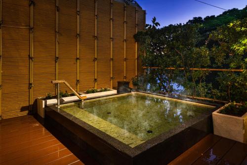 a bath tub in the middle of a garden at Hanashibuki in Tateyama