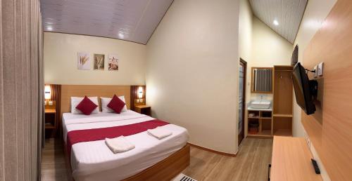 a bedroom with a large bed with red pillows at Rautani Sembalun in Sembalun Lawang