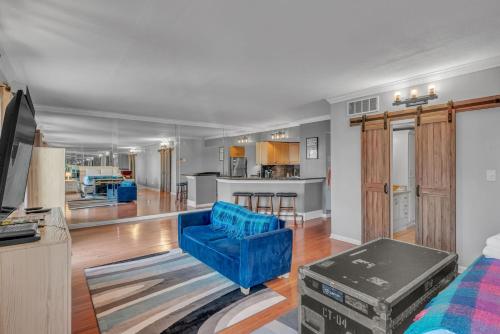a living room with a blue couch and a kitchen at Honky Tonk Angels Suite in Nashville