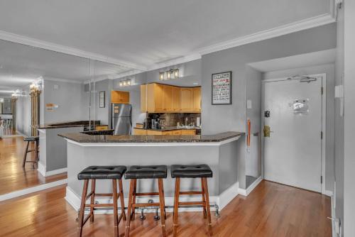 a kitchen with a bar with four stools at Honky Tonk Angels Suite in Nashville