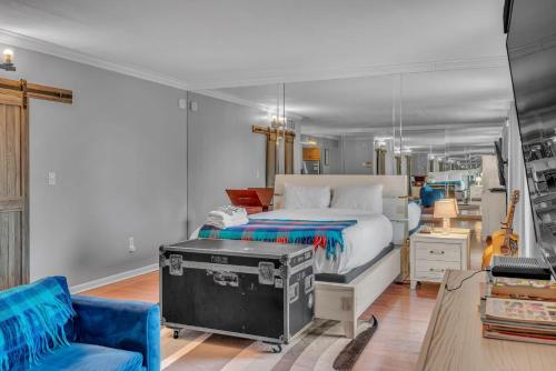 a bedroom with a bed and a blue chair at Honky Tonk Angels Suite in Nashville