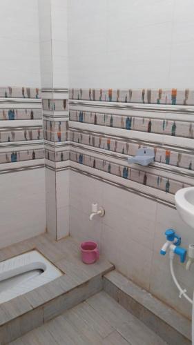 a bathroom with a sink and a toilet and a tub at Narsingh Sadan Home Stay in Ayodhya