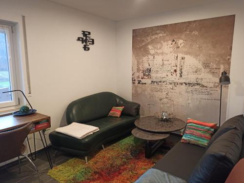 a living room with a green couch and a table at Reitstation Roßmühle in Gräfendorf