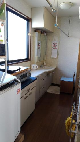 a kitchen with a sink and a window at OSO Homestay in Koshigaya