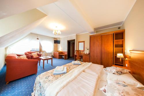 a hotel room with two beds and a living room at Pensjonat Pod Tatrami in Szaflary
