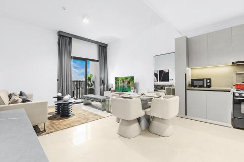 a living room with white furniture and a kitchen at Luxury 1BR City View with Balcony Parking & WiFi Near Dining & Downtown in Dubai