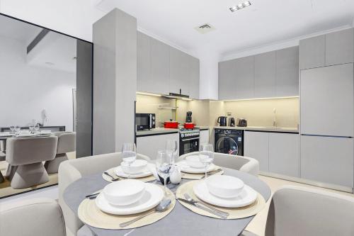 a dining room with a table and chairs and a kitchen at Luxury 1BR City View with Balcony Parking & WiFi Near Dining & Downtown in Dubai