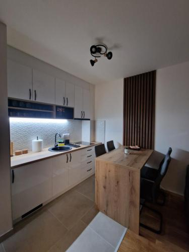 una cocina con mesa de madera y sillas. en My happy place Vrnjačka Banja, en Vrnjačka Banja