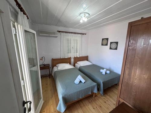 a small bedroom with two beds and a window at Kioni - Andriana's House in Kiónion