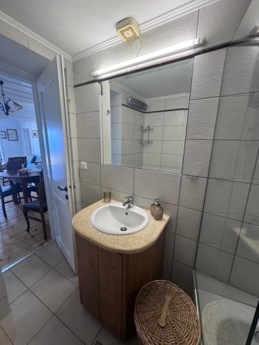 a bathroom with a sink and a mirror at Kioni - Andriana's House in Kiónion