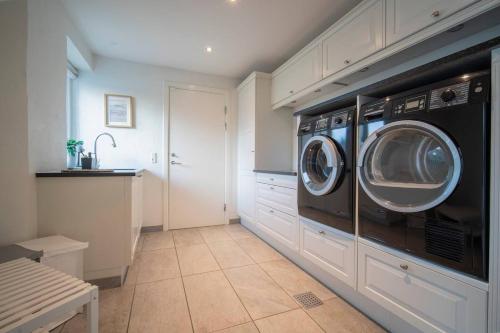 a laundry room with a washer and dryer at Villa Teglgårdshaven in Sindal