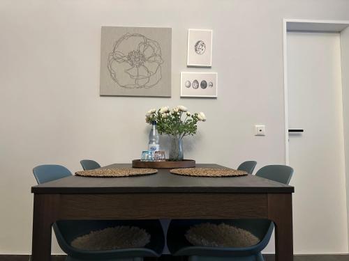 a dining room table with chairs and a vase of flowers at Attraktives City-Apartment No5 in Bremen