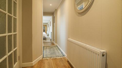 a hallway with a radiator and a mirror on the wall at Modern And Cozy Apex Apartment in Helensburgh