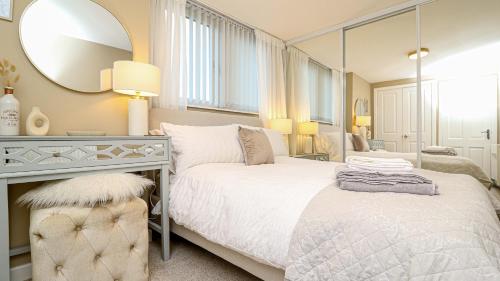 a bedroom with a white bed and a mirror at Modern And Cozy Apex Apartment in Helensburgh